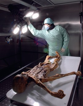A researcher stands over the body of Ötzi the Iceman, a 5,000-year-old mummy found on the mountainous border of Austria and Italy