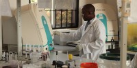 Technician using a Bactec machine which cultures bacteria from blood, stool, and urine samples. The machine allows researchers to eliminate other infectious diseases when looking at malaria cases.